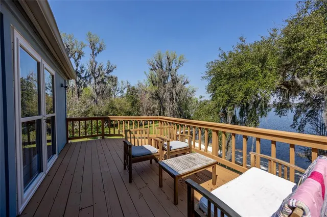 a view of a balcony with wooden floor and outdoor seating