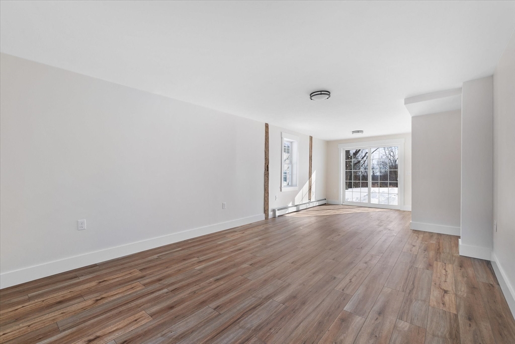 67 Maple Street Oakham, MA 01068 - Photo 21 of 41 a view of an empty room with wooden floor and a window