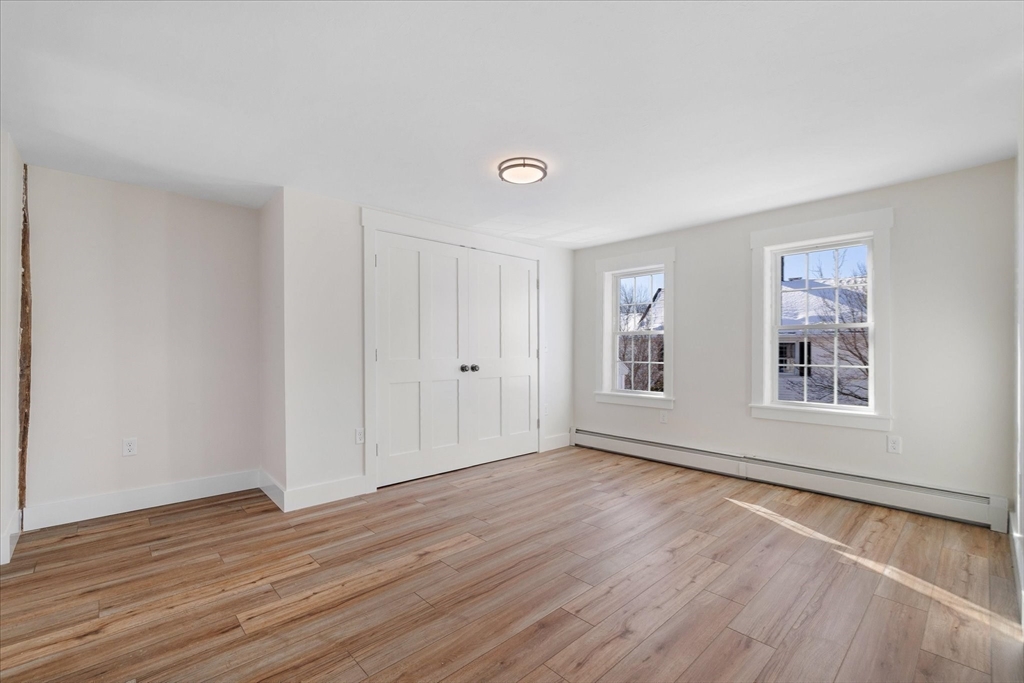 67 Maple Street Oakham, MA 01068 - Photo 26 of 42 a view of an empty room with wooden floor and a window