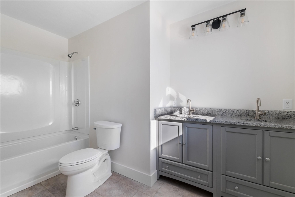 67 Maple Street Oakham, MA 01068 - Photo 28 of 41 a bathroom with a granite countertop toilet a sink and a bathtub