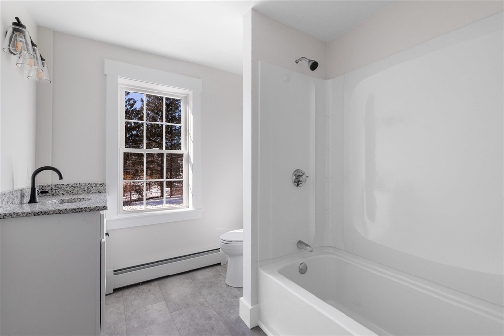 67 Maple Street Oakham, MA 01068 - Photo 31 of 41 a bathroom with a granite countertop sink a window and shower