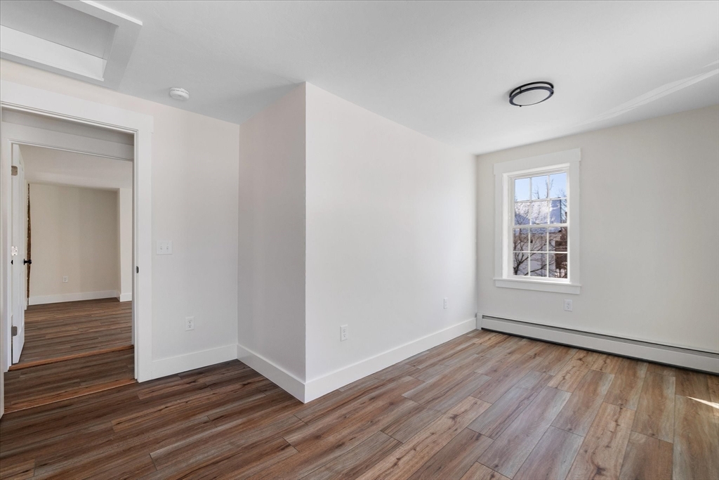 67 Maple Street Oakham, MA 01068 - Photo 38 of 42 a view of an empty room with wooden floor and a window
