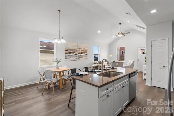 a kitchen with a sink stove and wooden floor