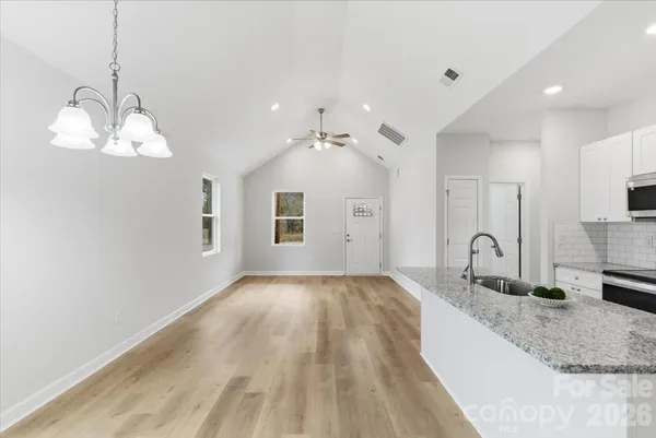 a spacious bathroom with a granite countertop sink a mirror and vanity