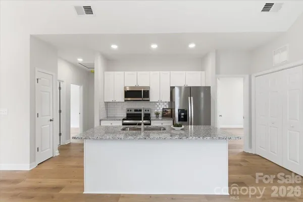 a kitchen with stainless steel appliances granite countertop a refrigerator and a stove