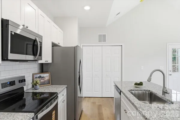 a kitchen with stainless steel appliances granite countertop a sink stove and refrigerator