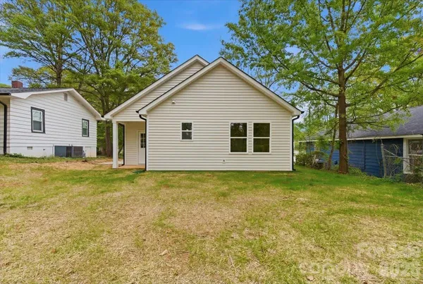 a view of a backyard with plants and large tree