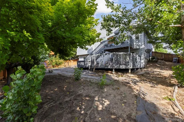 a view of a wooden deck with furniture and a yard