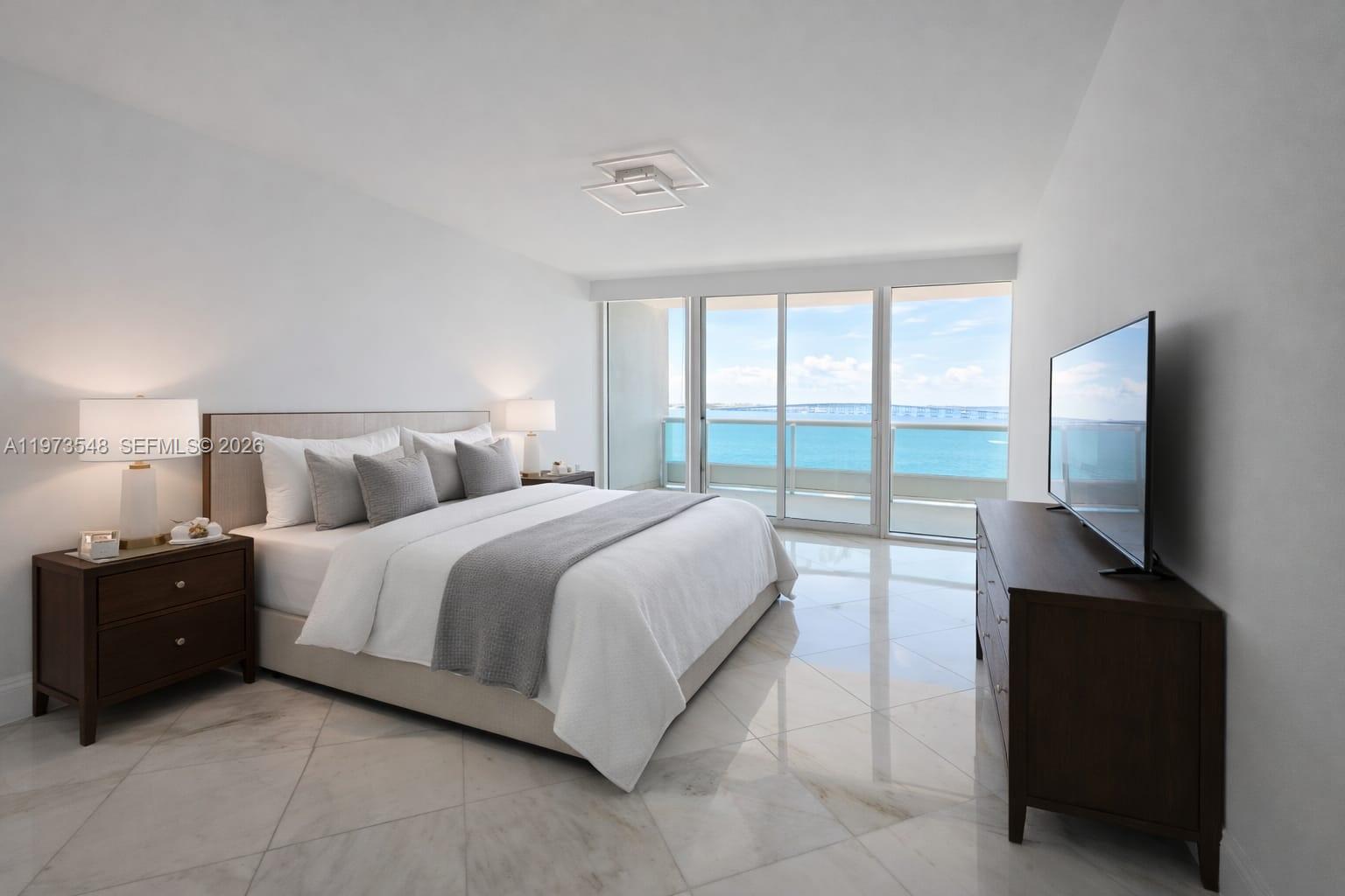 1643 Brickell Avenue, Unit 903 Miami, FL 33129 - Photo 14 of 18 a bedroom with a bed and a flat tv screen on dresser