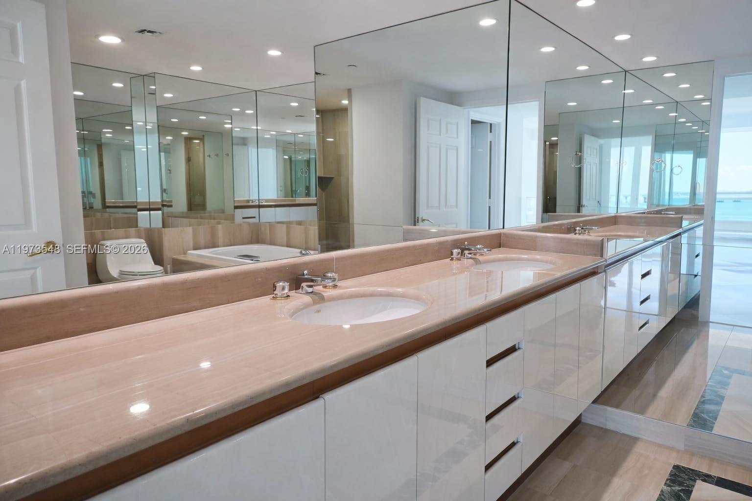 1643 Brickell Avenue, Unit 903 Miami, FL 33129 - Photo 15 of 18 a bathroom with a granite countertop sink large mirror and shower