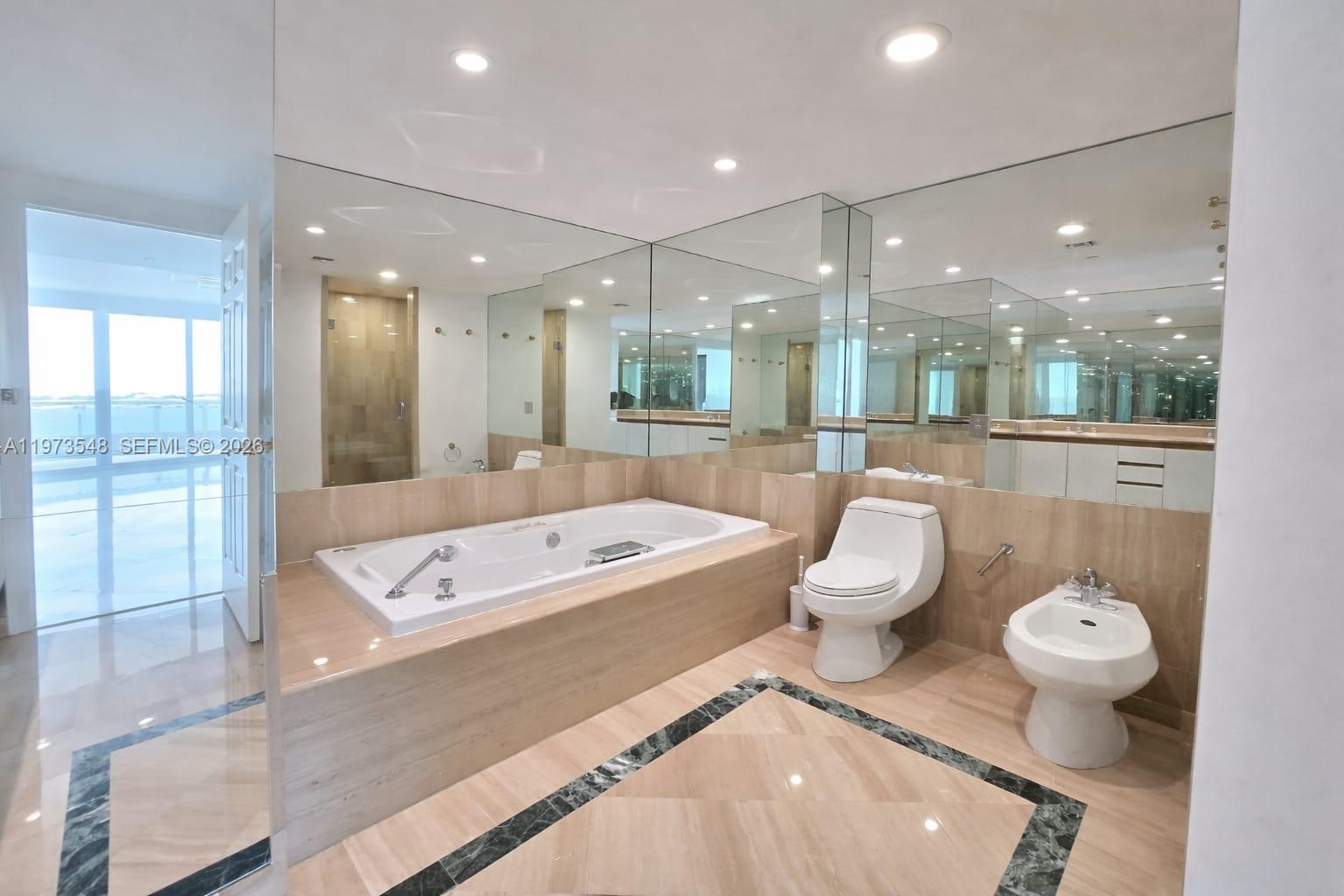 1643 Brickell Avenue, Unit 903 Miami, FL 33129 - Photo 16 of 18 a large bathroom with a large tub and toilet