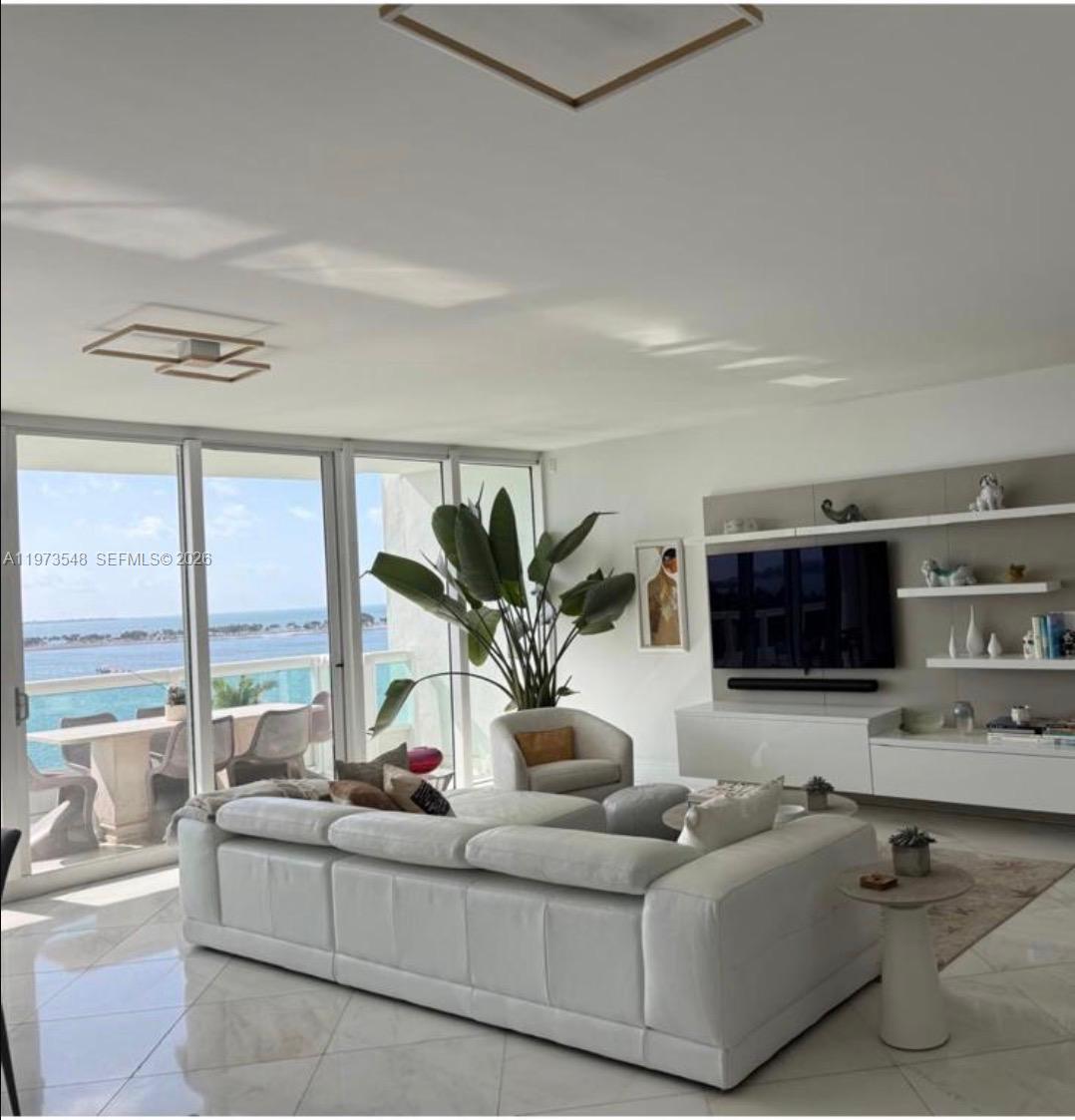 1643 Brickell Avenue, Unit 903 Miami, FL 33129 - Photo 8 of 18 a living room with furniture flat screen tv and a large window