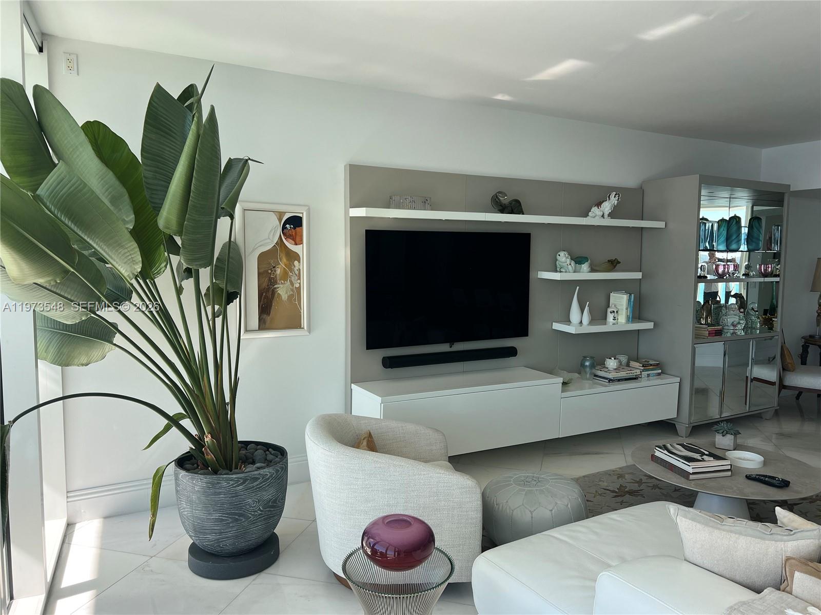 1643 Brickell Avenue, Unit 903 Miami, FL 33129 - Photo 9 of 18 a living room with furniture a potted plant and a rug
