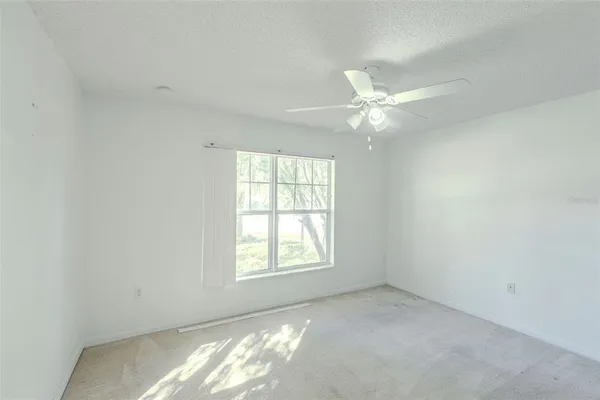 a view of a room with a ceiling fan and a closet