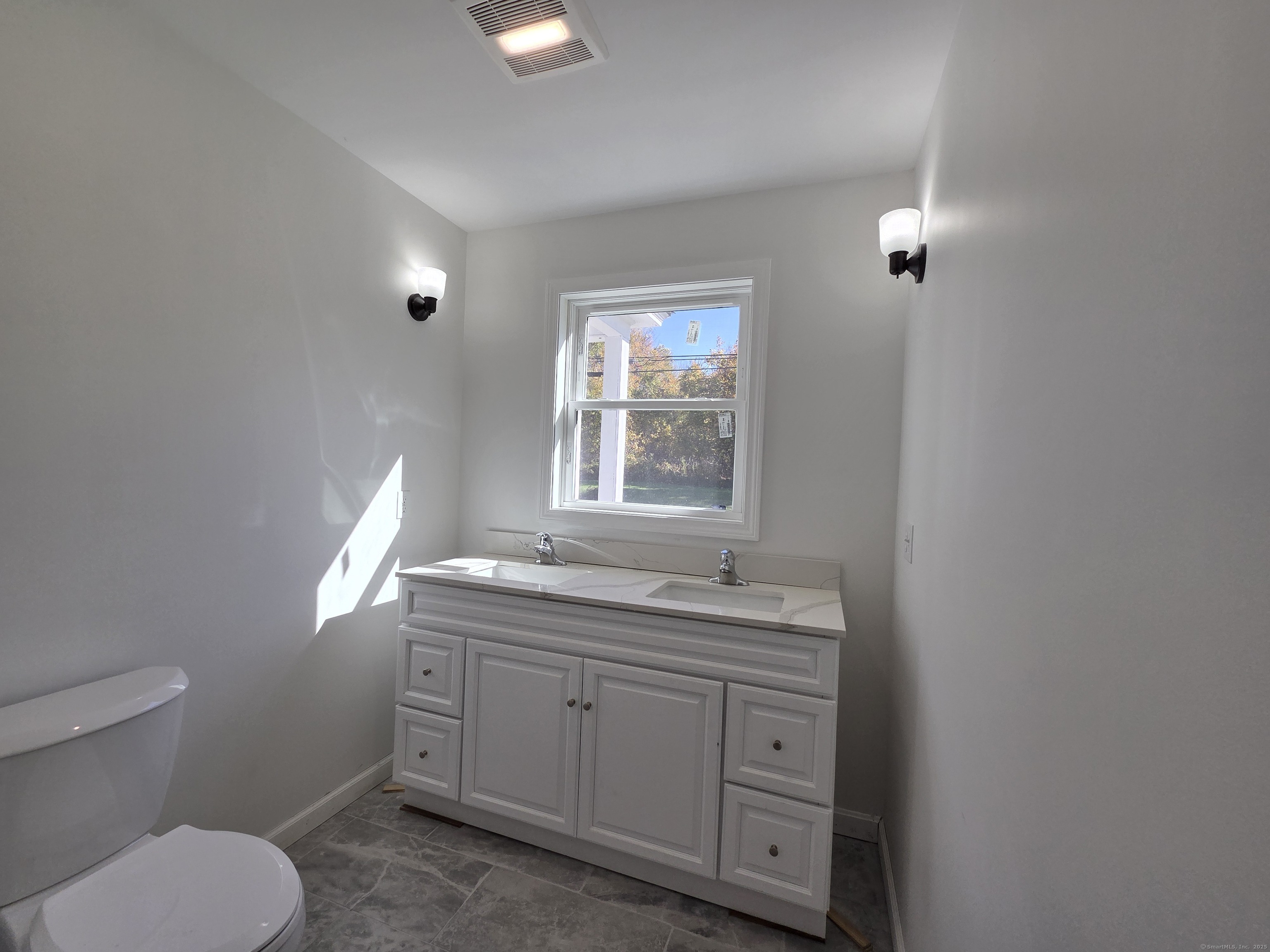 395 Bailey Hill Road Killingly, CT 06239 - Photo 14 of 36 a bathroom with a granite countertop toilet a sink and a window