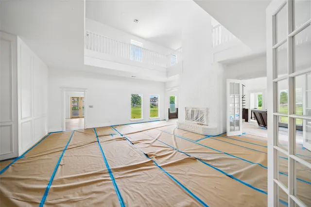 a view of a livingroom with wooden floor and a kitchen