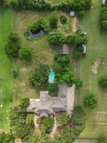 an aerial view of a house with a yard and lake view