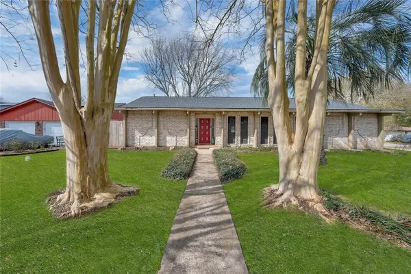 a front view of a house with a garden and yard