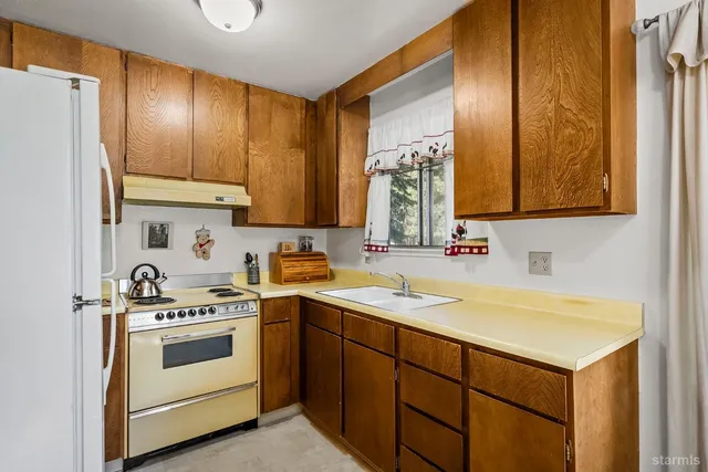 a view of cabinets a sink and a refrigerator in a room
