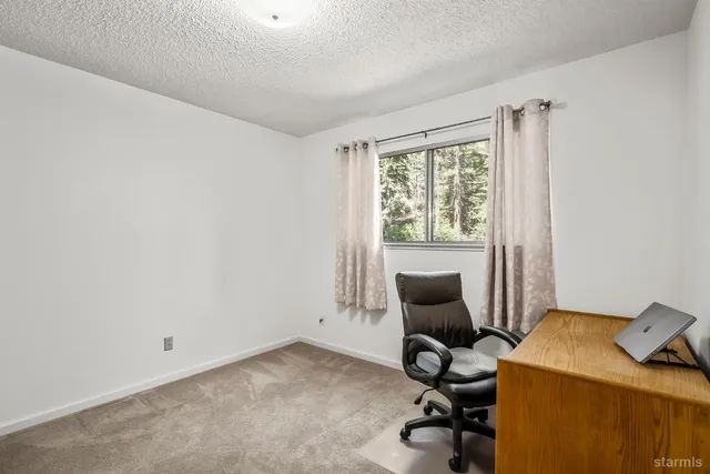 a view of a workspace with furniture and a window