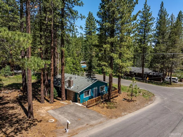 a view of a house with backyard and trees