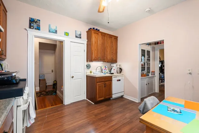 a kitchen with a sink dishwasher a stove a microwave oven with a dining table and chairs