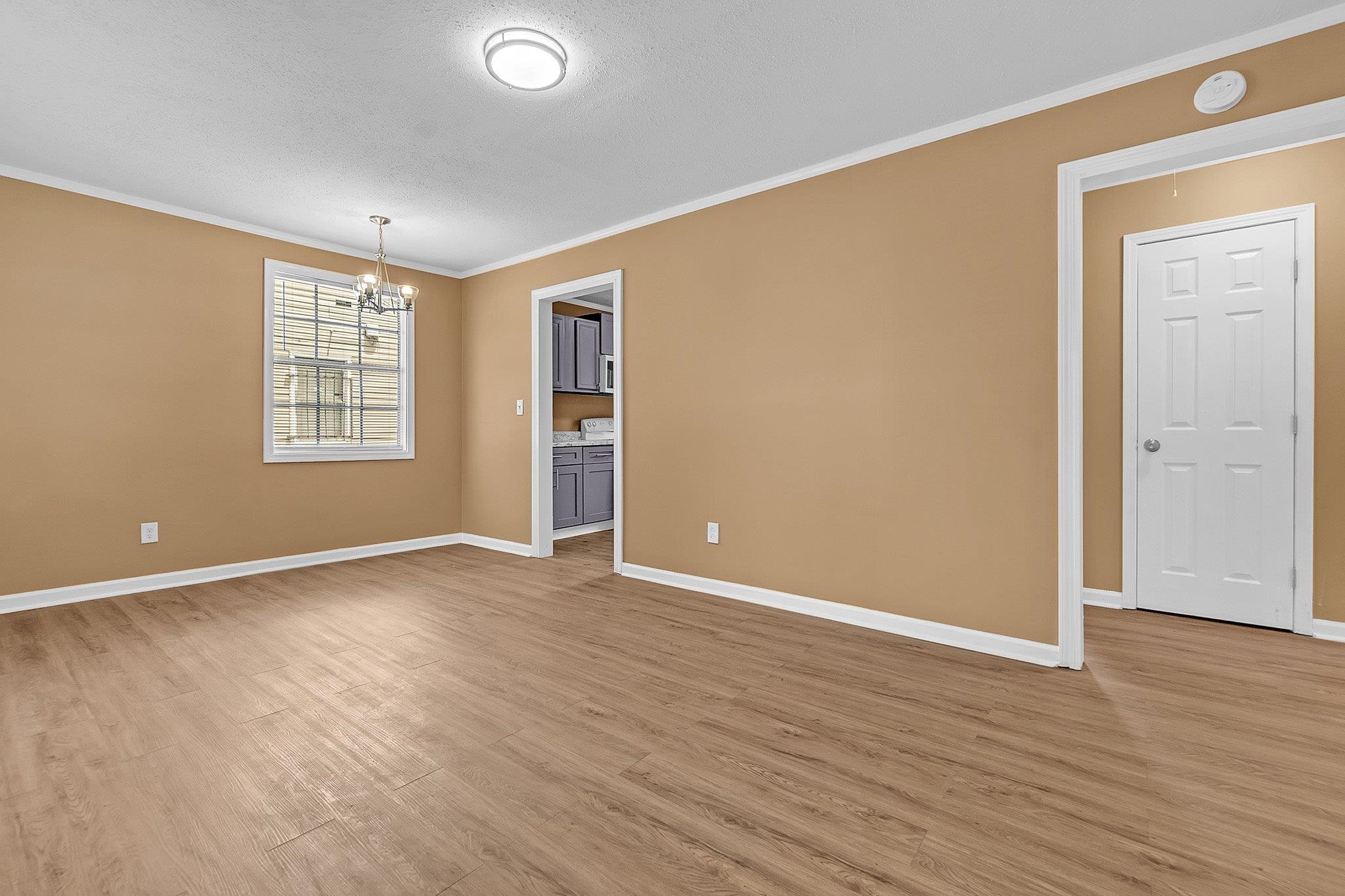3186 Alta Road Memphis, TN 38109 - Photo 4 of 14 Spacious room featuring wood-finish flooring, a contemporary ceiling light fixture, and a window with blinds