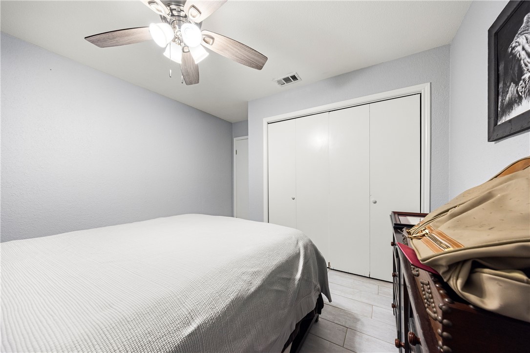 15730 Escapade Street Corpus Christi, TX 78418 - Photo 15 of 22 a bedroom with a bed and a chandelier