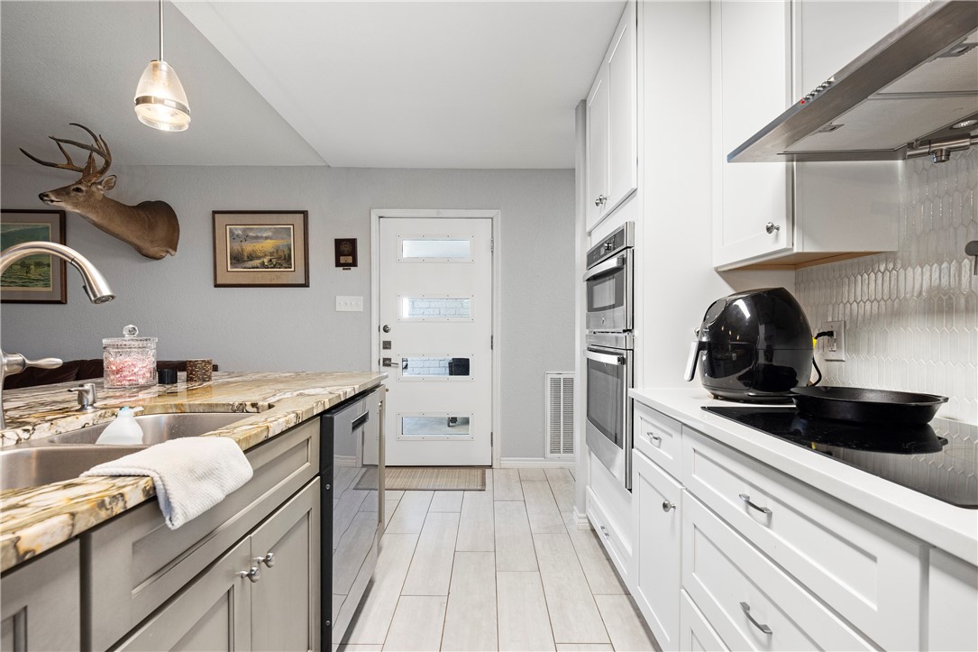 15730 Escapade Street Corpus Christi, TX 78418 - Photo 4 of 22 a kitchen with a sink stove and cabinets