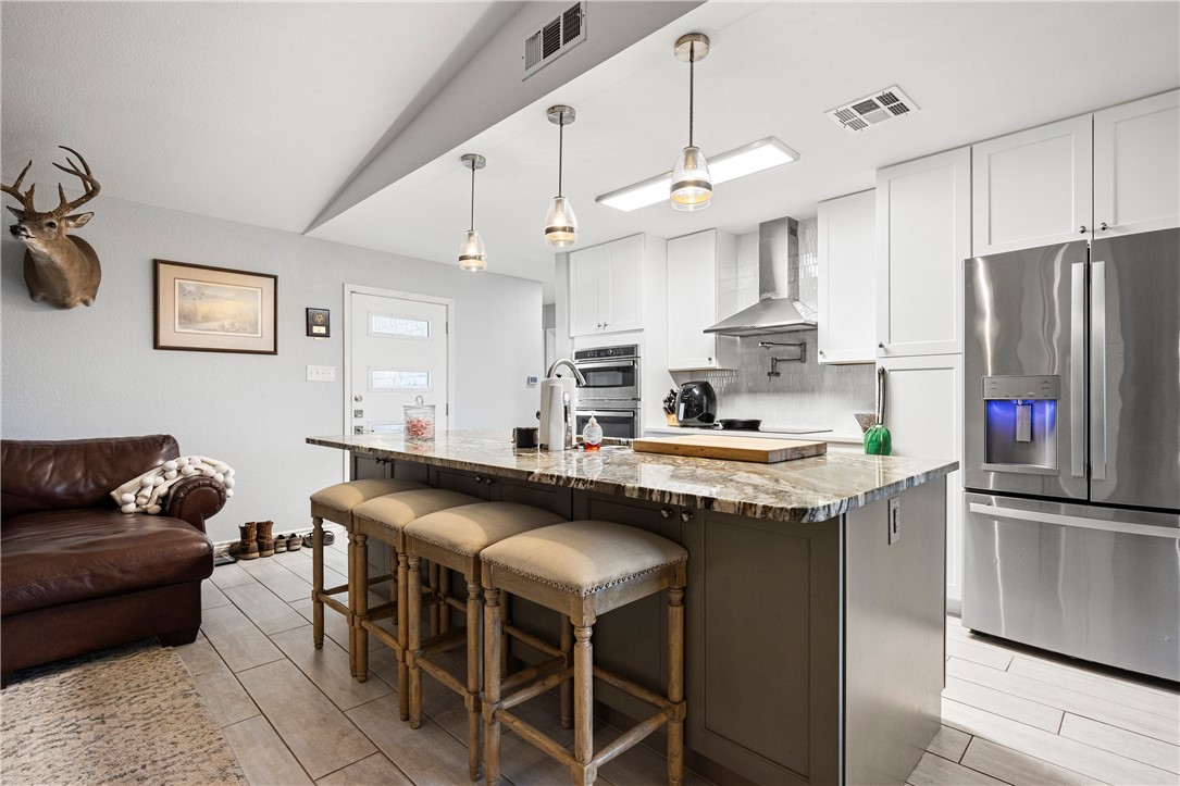 15730 Escapade Street Corpus Christi, TX 78418 - Photo 5 of 22 a kitchen with stainless steel appliances granite countertop a table chairs sink and cabinets