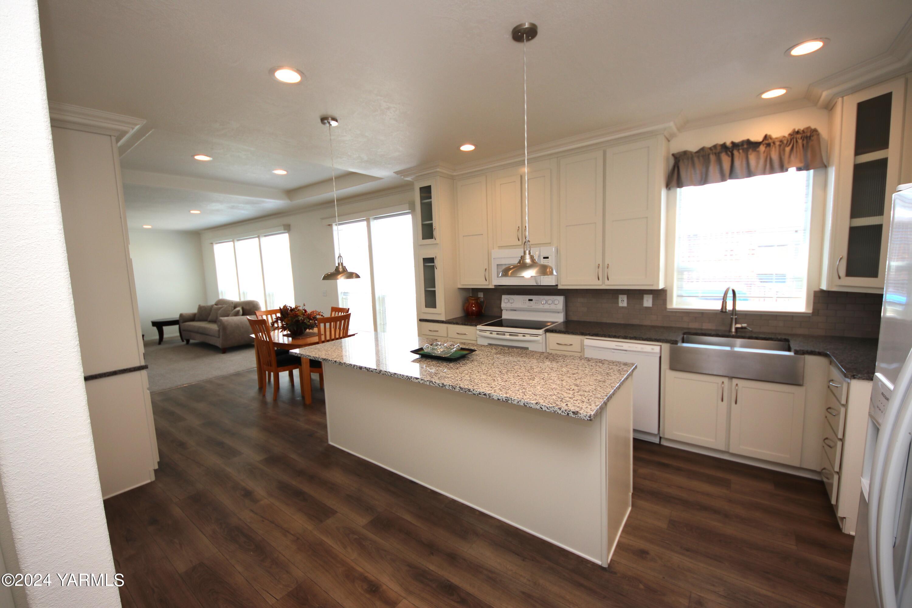 a large white kitchen with granite countertop lots of counter top space