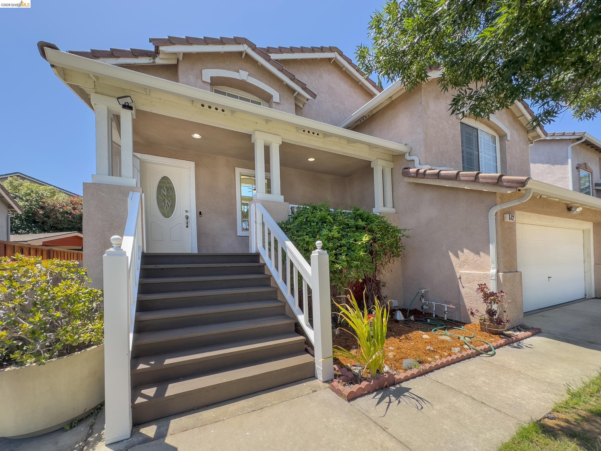 512 Burdick Drive Bay Point, CA 94565 - Photo 3 of 50 Stucco exterior featuring a covered front porch with recessed lighting, white columns, and a white entry door with an oval-shaped decorative glass insert