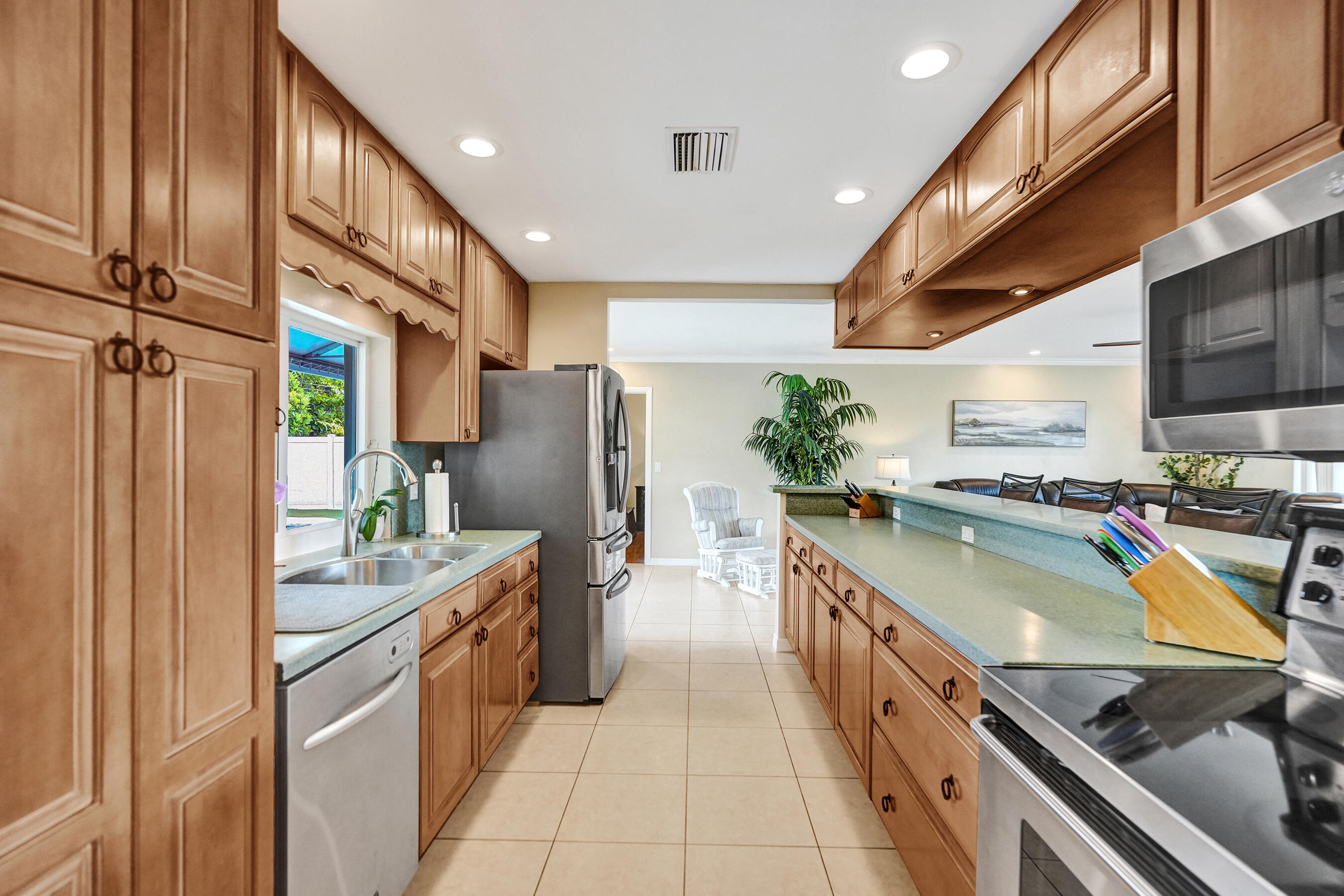 3001 Northeast 45th Street Lighthouse Point, FL 33064 - Photo 16 of 67 a kitchen with stainless steel appliances granite countertop a sink counter space cabinets and a stove