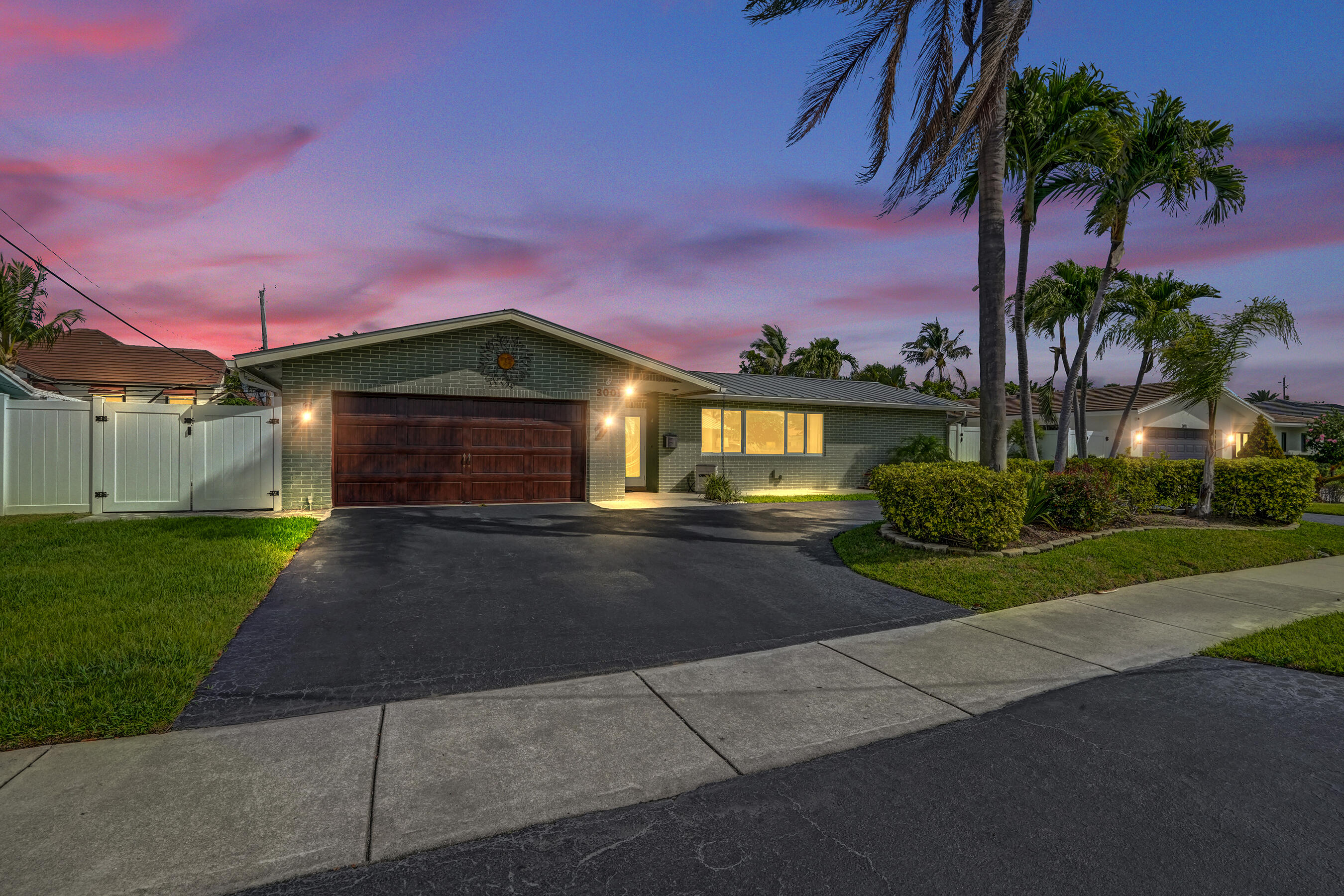 3001 Northeast 45th Street Lighthouse Point, FL 33064 - Photo 4 of 67 a front view of a house with a yard and garage