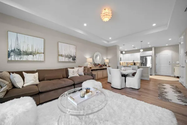 a living room with furniture and a dining table with wooden floor