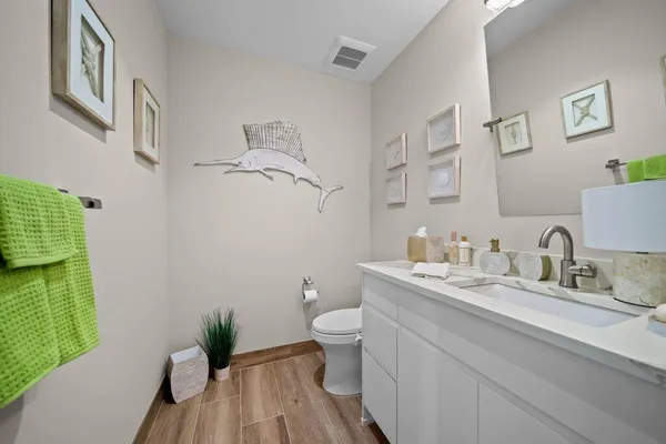 a bathroom with a granite countertop sink a toilet and a mirror