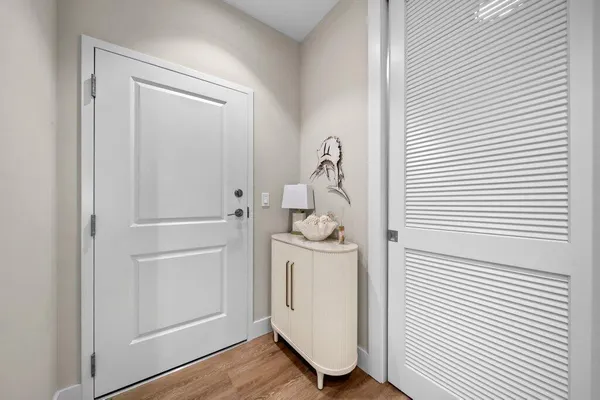 a view of a hallway with white cabinets