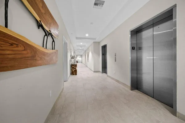 a view of a hallway with wooden cabinets and staircase