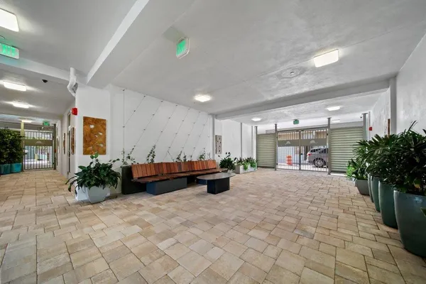 a large room with furniture and potted plants