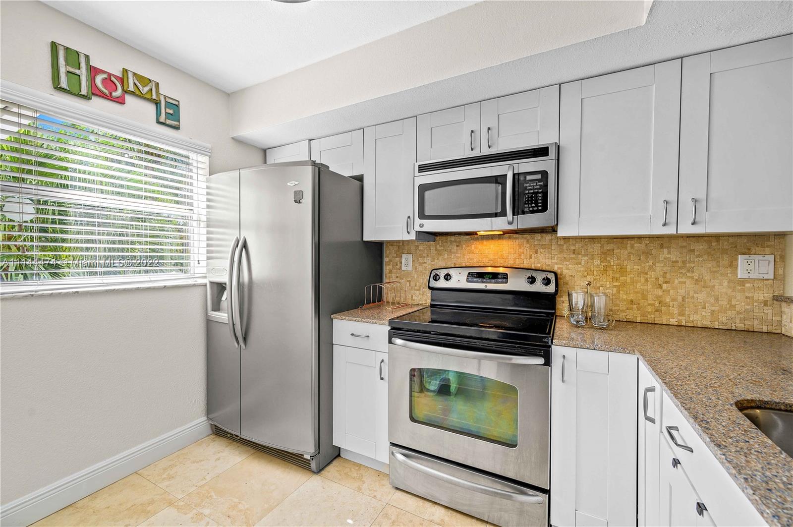 4600 Southwest 67th Avenue, Unit 240 Miami, FL 33155 - Photo 3 of 20 a kitchen with granite countertop cabinets stainless steel appliances and a window