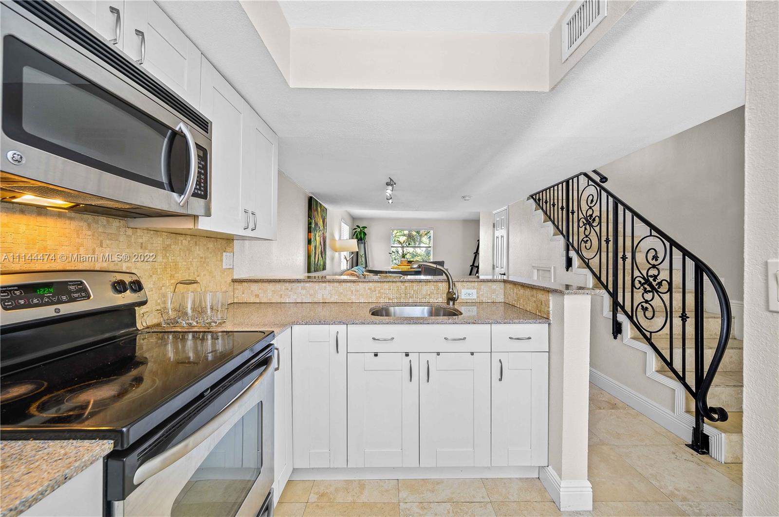 4600 Southwest 67th Avenue, Unit 240 Miami, FL 33155 - Photo 4 of 20 a kitchen with granite countertop a stove and a sink