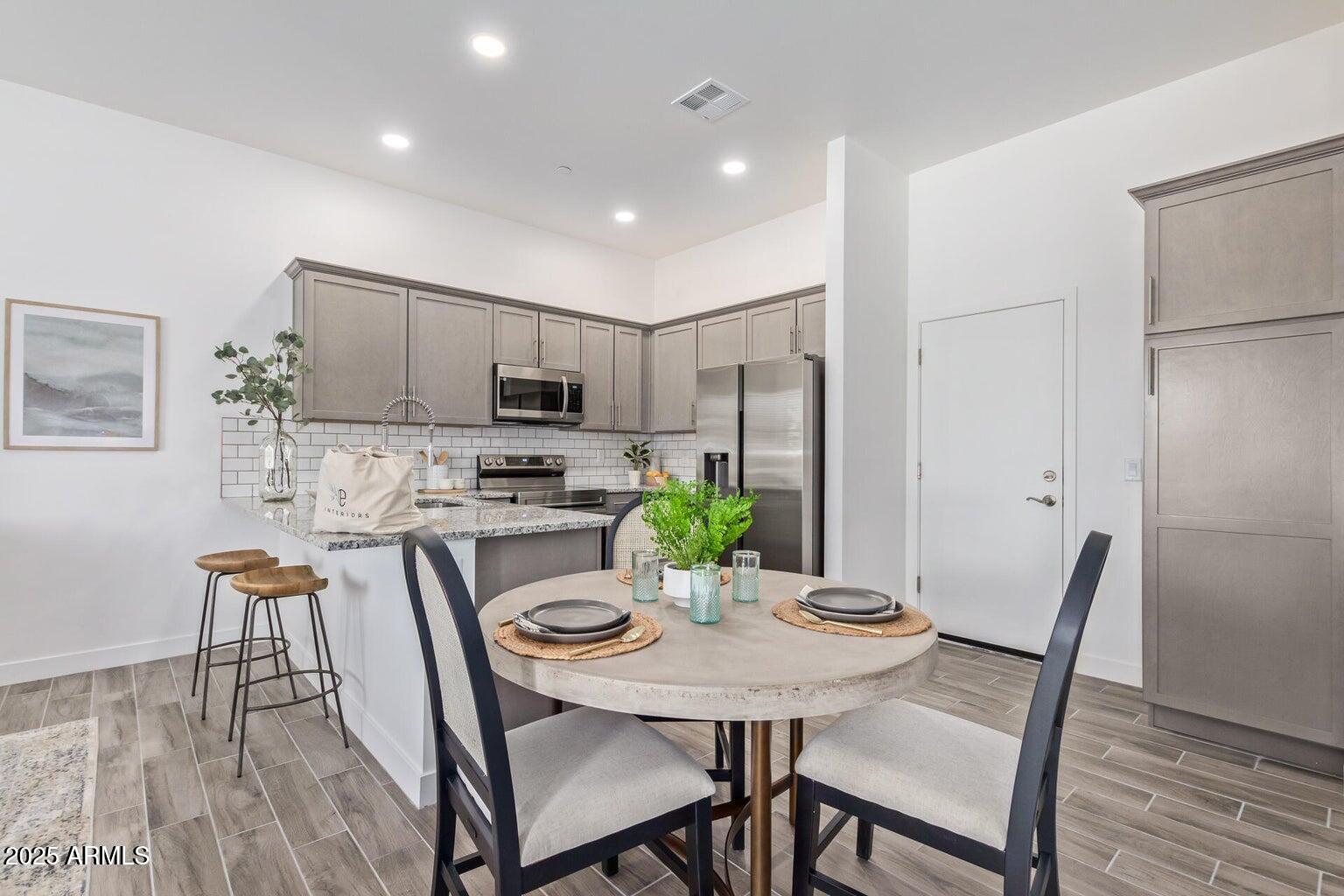 3230 East Thomas Road, Unit 114 Mesa, AZ 85213 - Photo 11 of 27 a view of a dining room with furniture and wooden floor