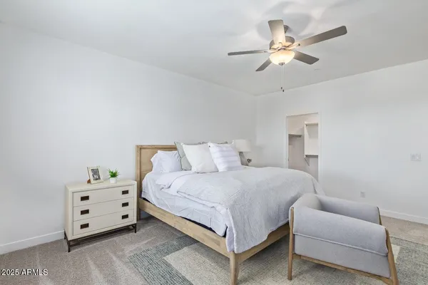 a bedroom with a bed and lamp on dresser