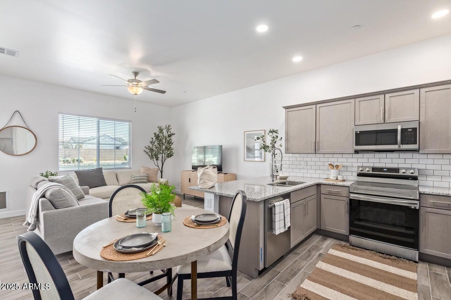 3230 East Thomas Road, Unit 114 Mesa, AZ 85213 - Photo 7 of 27 a view of a dining room with furniture a kitchen and chandelier