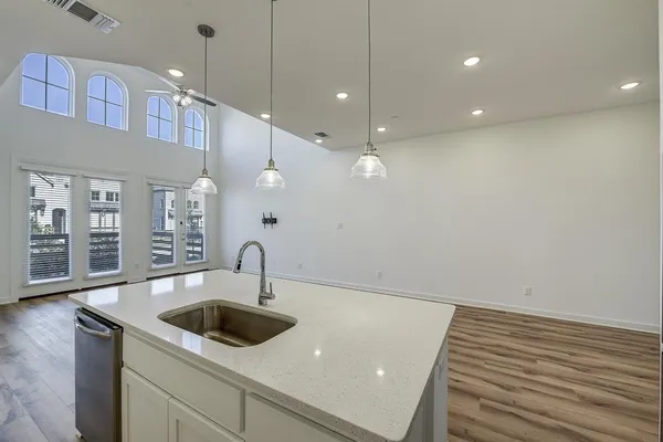 a kitchen with granite countertop a sink a counter space and cabinets
