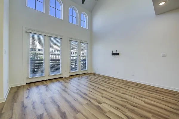 an empty room with wooden floor and windows