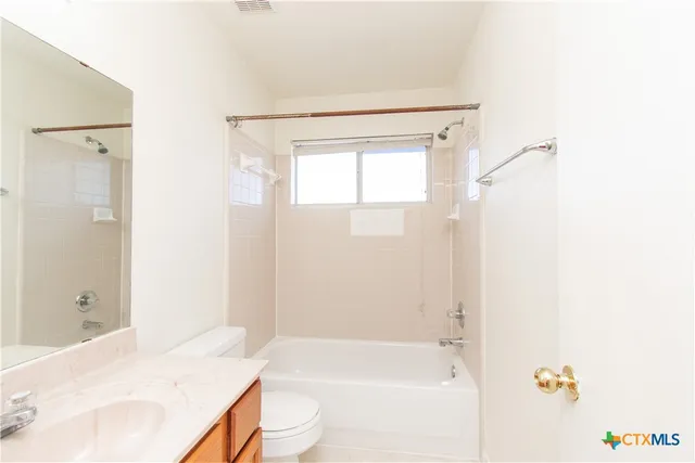 a bathroom with a bathtub shower sink vanity and a toilet