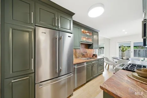 a kitchen with stainless steel appliances granite countertop a refrigerator and a stove top oven