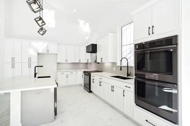 an empty room with wooden floor chandelier fan and windows