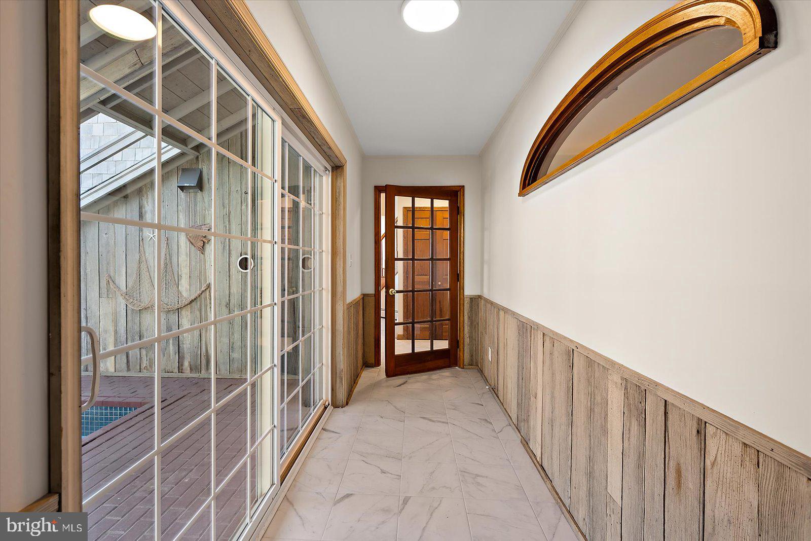 10148 Champ Road Princess Anne, MD 21853 - Photo 44 of 77 a view of a hallway with wooden floor and windows